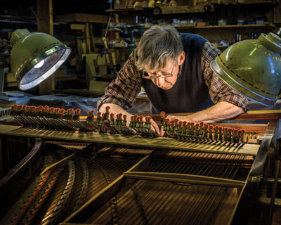 Adams doing restoration work on a Pleyel harpsichord. Photo by Paul Cary Goldberg ©2016.